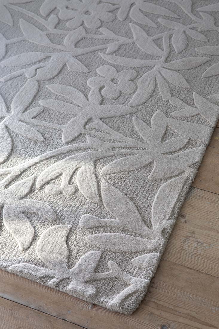Beige wool rug with hand carved floral motifs
