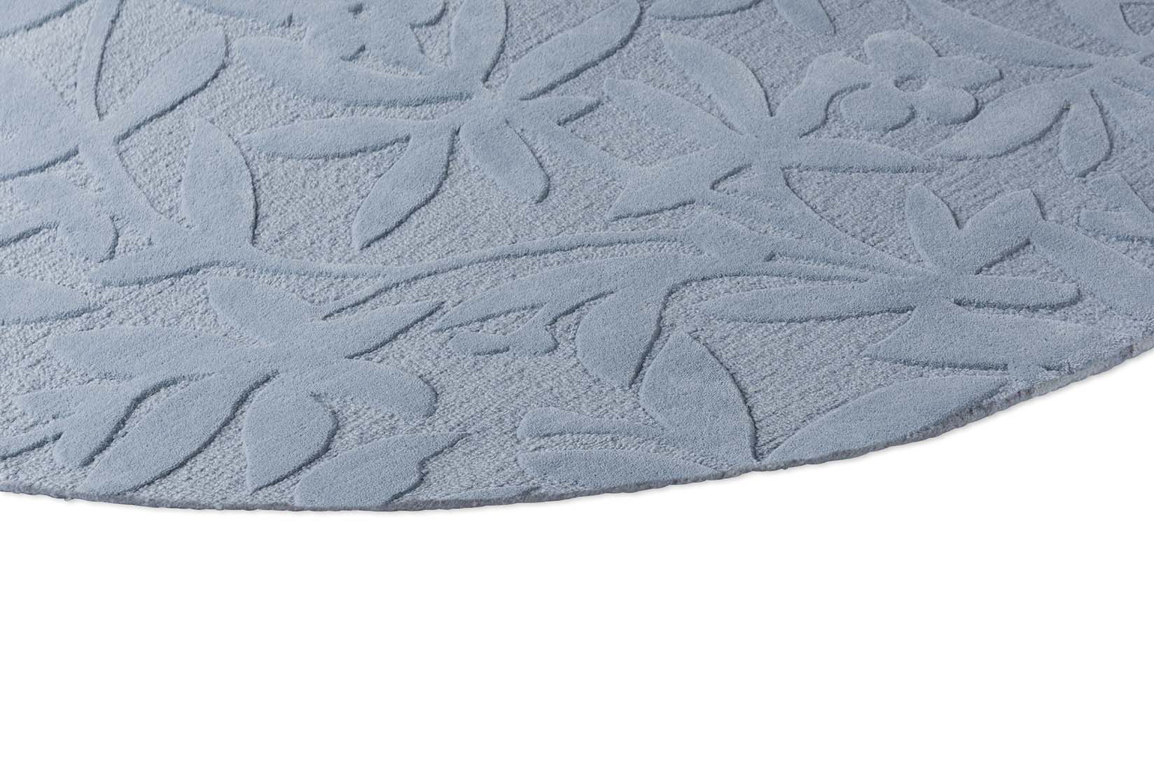 Blue wool circular rug with hand carved floral motifs