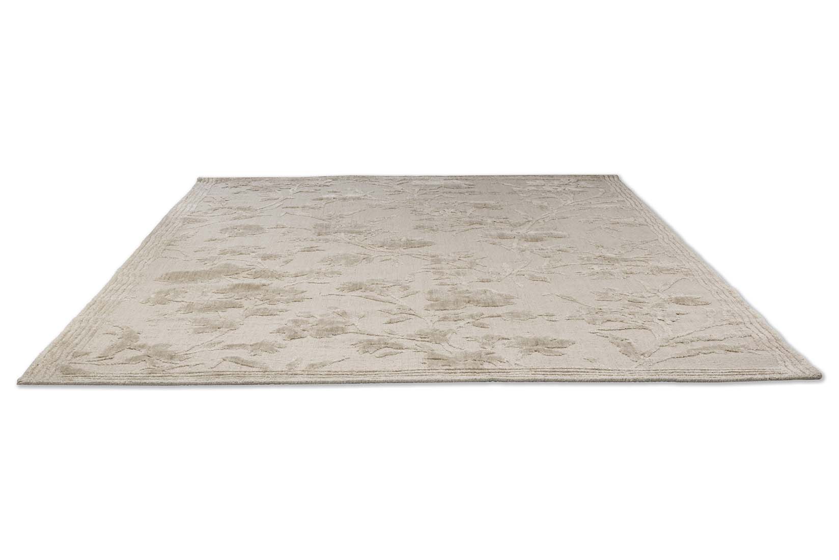 cotton and wool rug in beige with floral design.