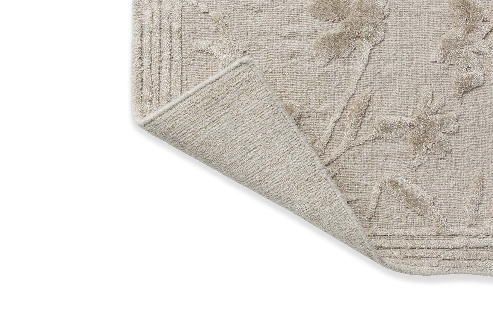 cotton and wool rug in beige with floral design.