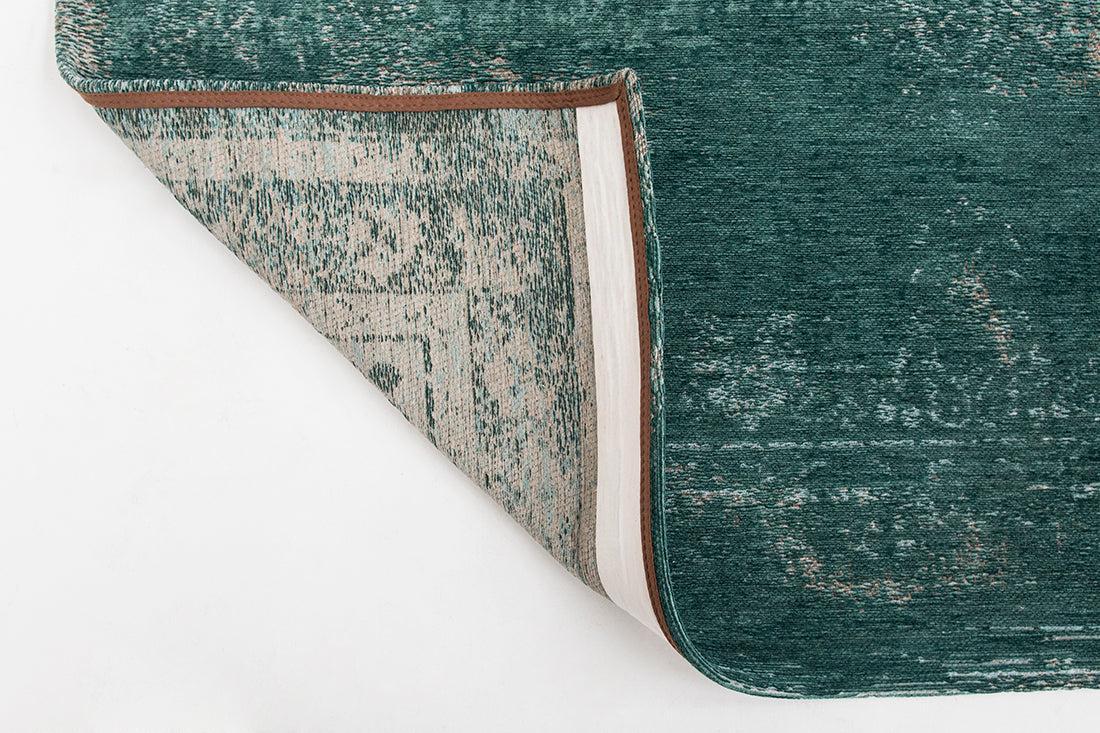 green flatweave rug with faded persian design