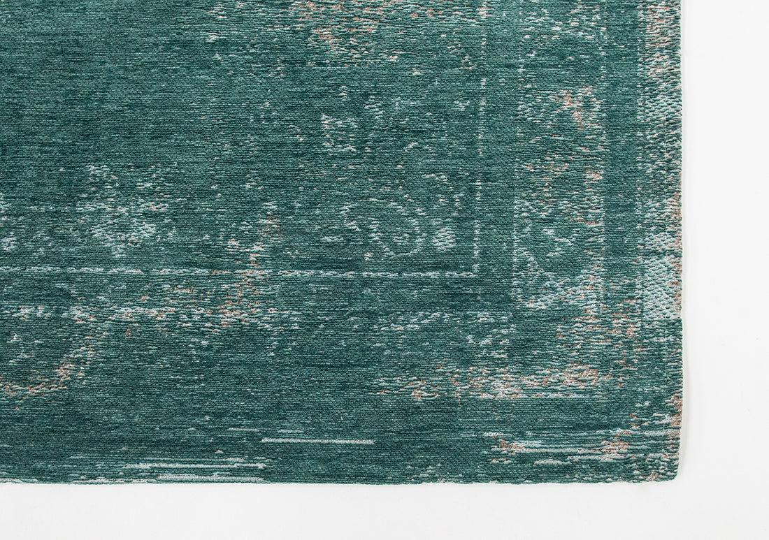 green flatweave rug with faded persian design