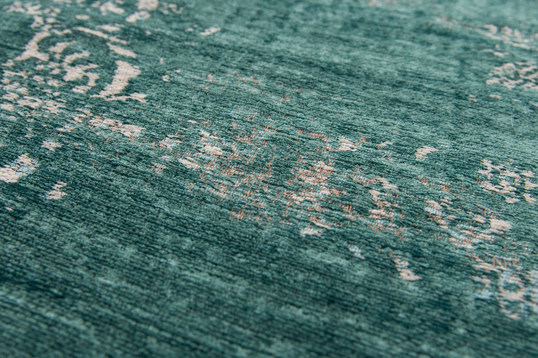 green flatweave rug with faded persian design