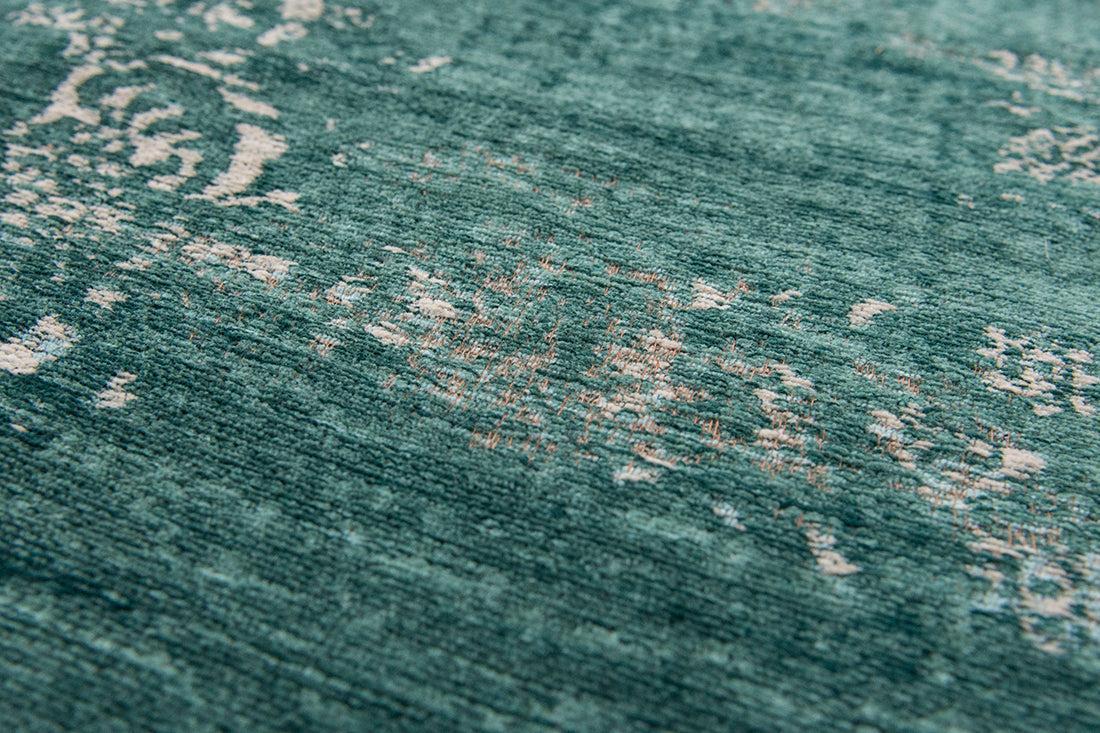 green flatweave rug with faded persian design