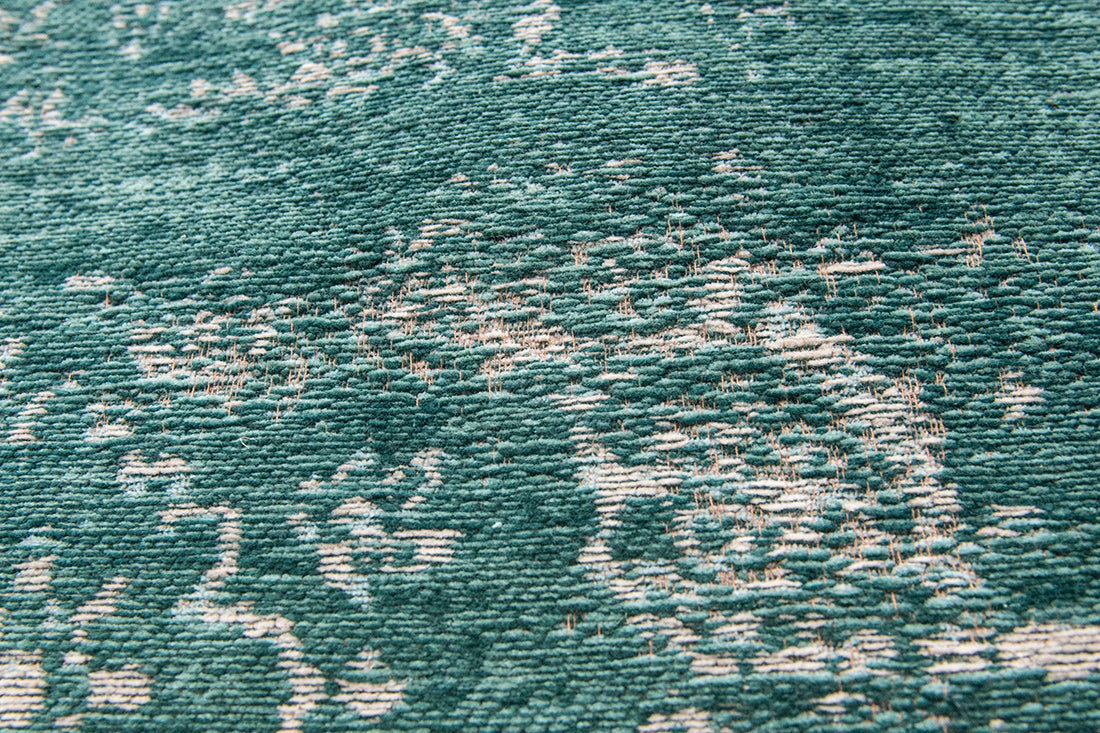 green flatweave rug with faded persian design