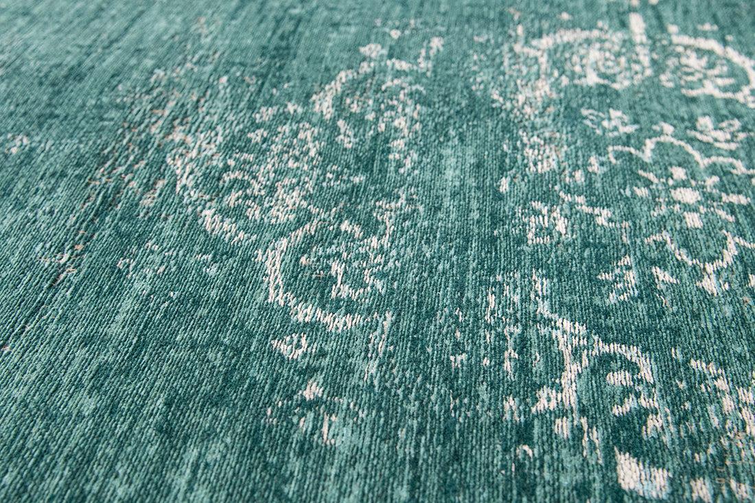 green flatweave rug with faded persian design