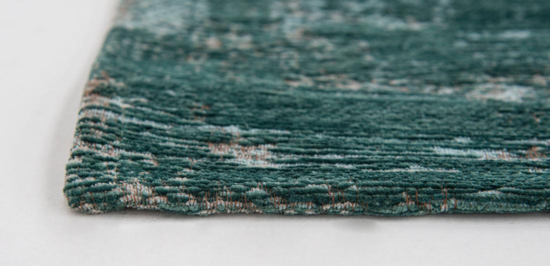 green flatweave rug with faded persian design