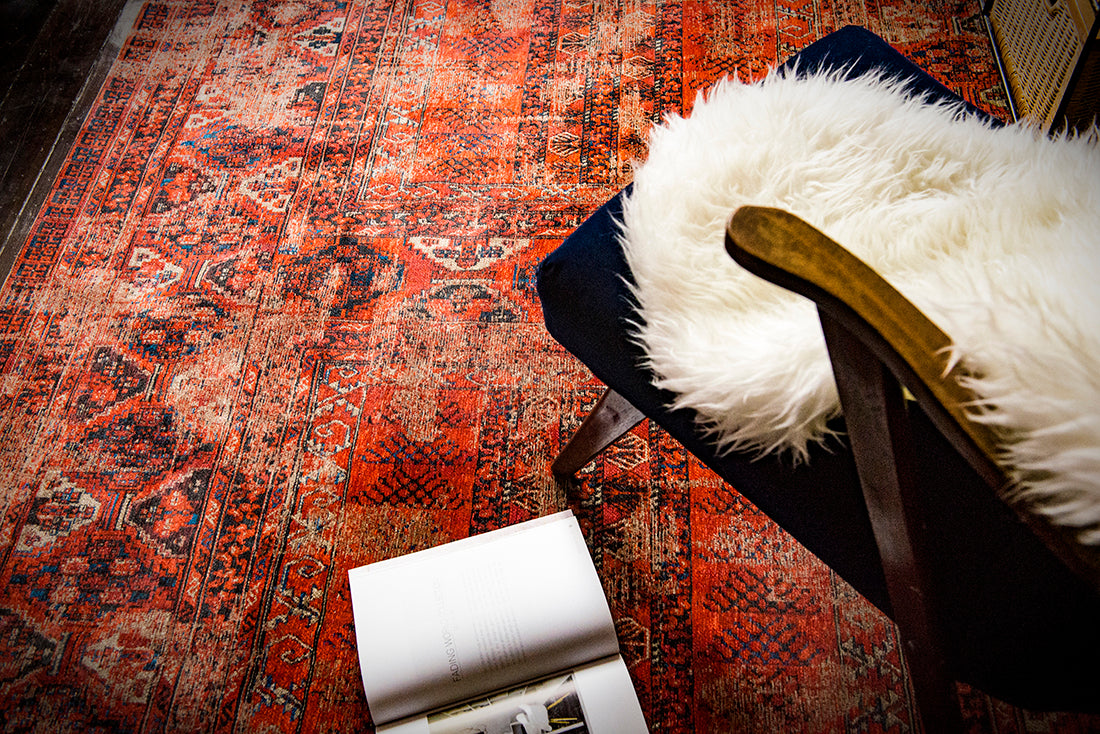 Red flatweave rug with faded persian design of floral motifs and gul medallions