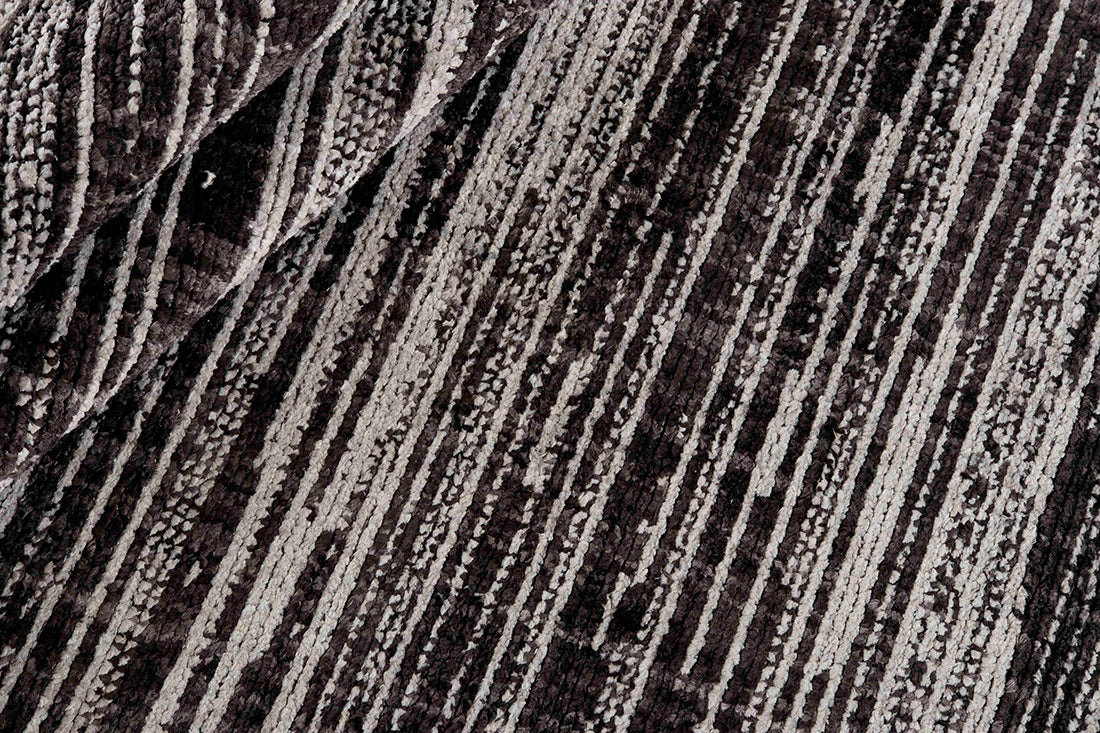 Grey rug with a subtle striped black pattern 
