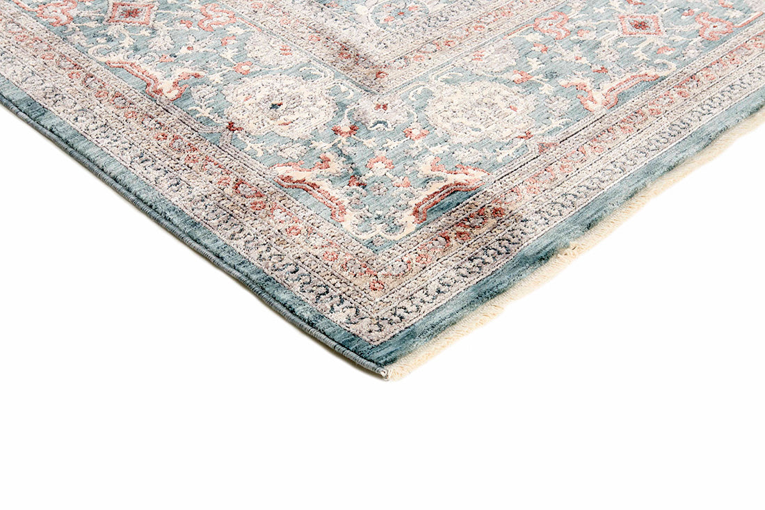 Traditional style rug with beige backing and teal patterned border design
