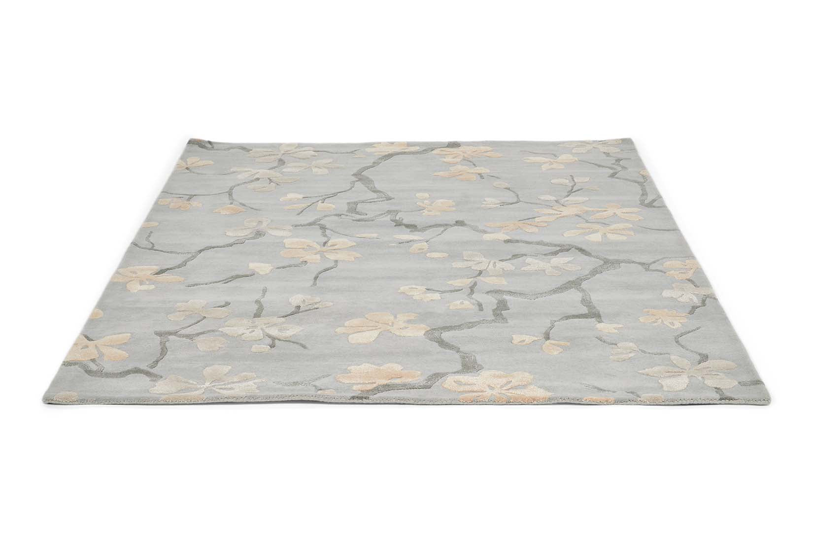 Rectangular blue rug with dark blue branch design and white flowers and leaves