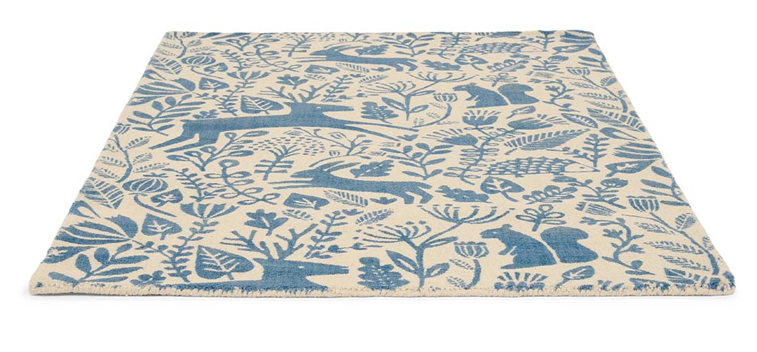 blue wool rug with a delicate woodland design