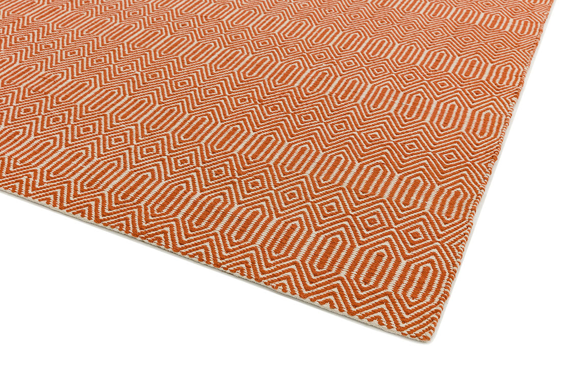 orange and white woven rug with aztec chevron pattern