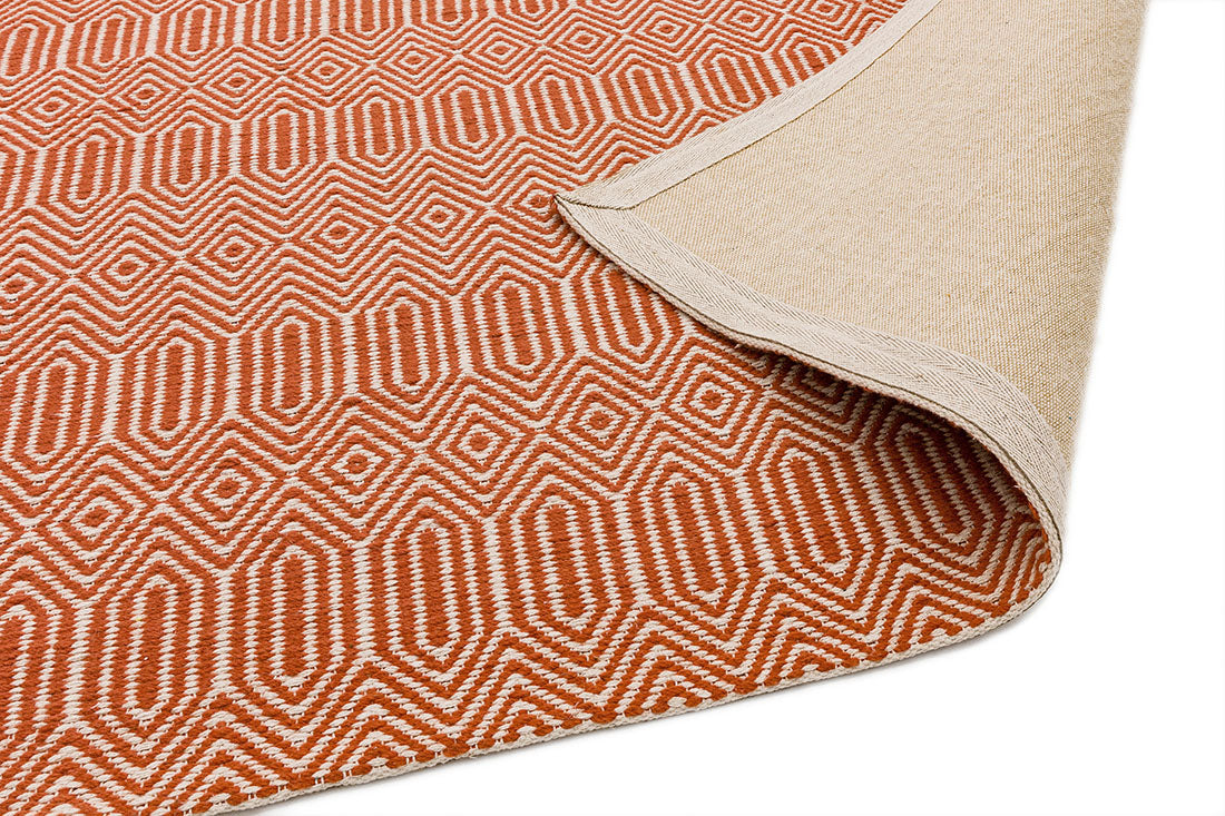 orange and white woven rug with aztec chevron pattern