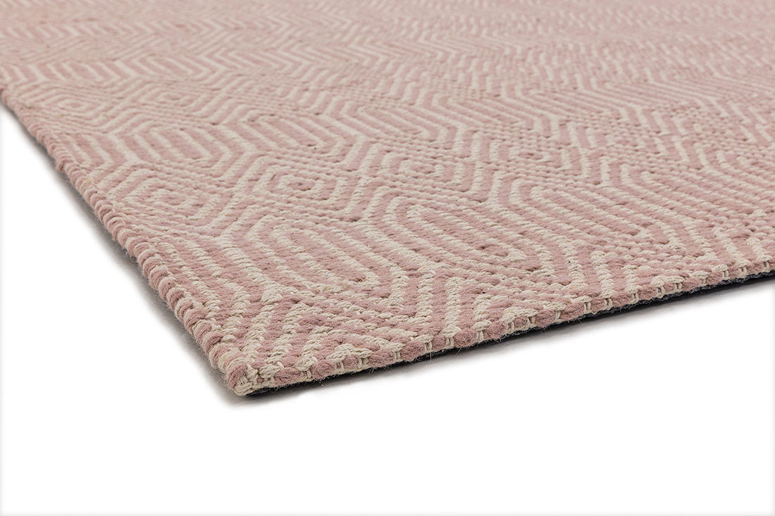 pink and white rug with a geometric aztec pattern