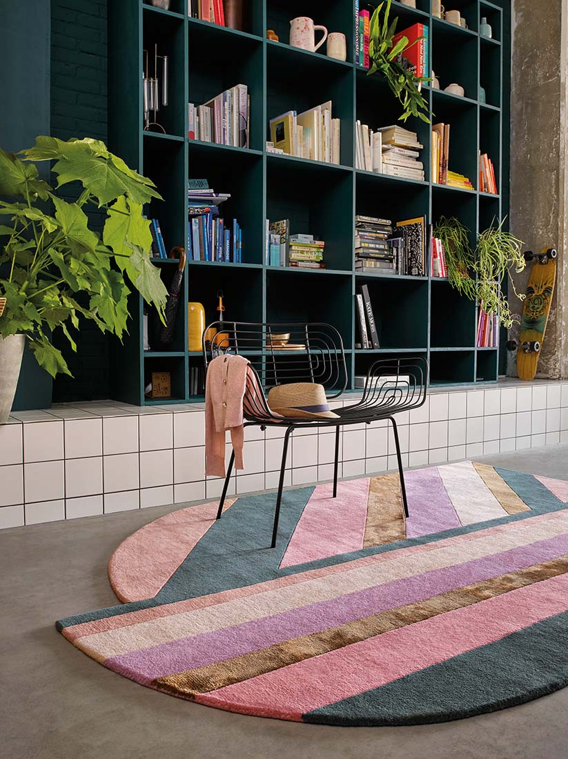 Striped pink, teal and gold rug in an abstract shape