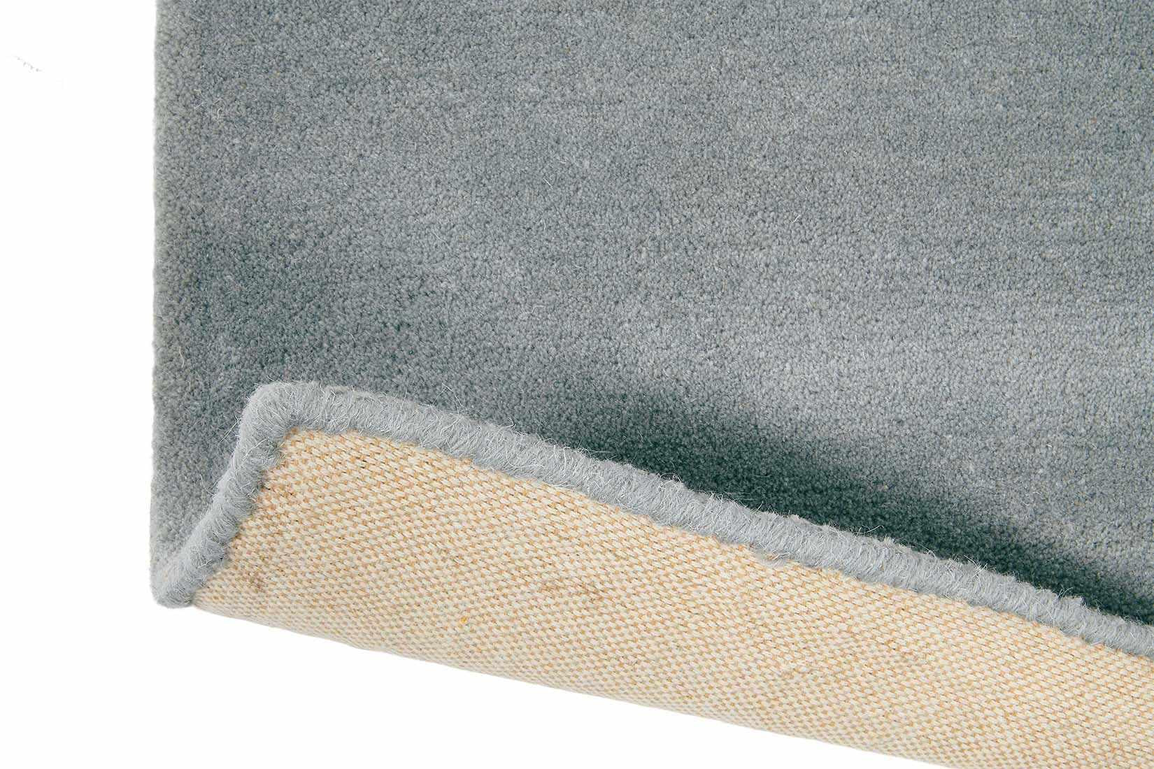 Rectangular rug with pink, grey and blue plaid pattern.