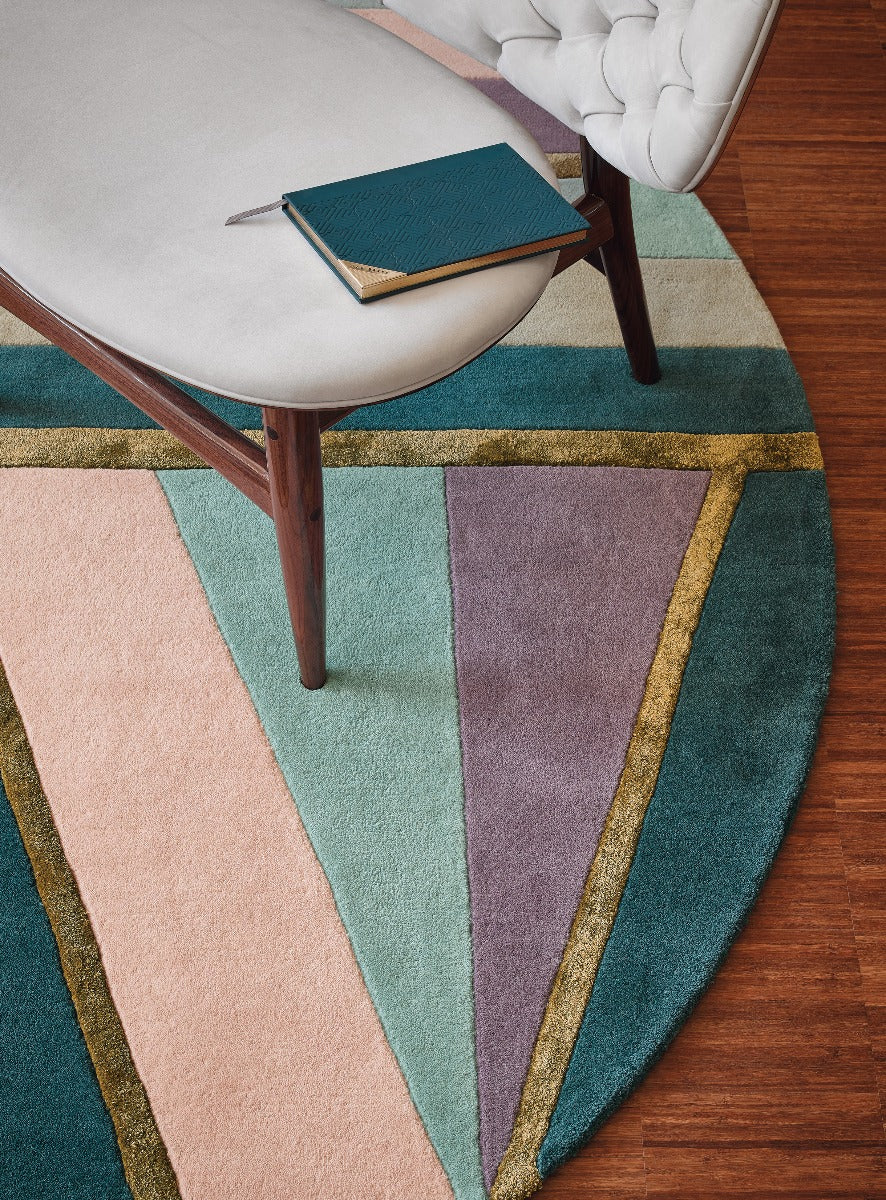 Modern rug with geometric stripe pattern in green, teal, grey and purple. Gold details.