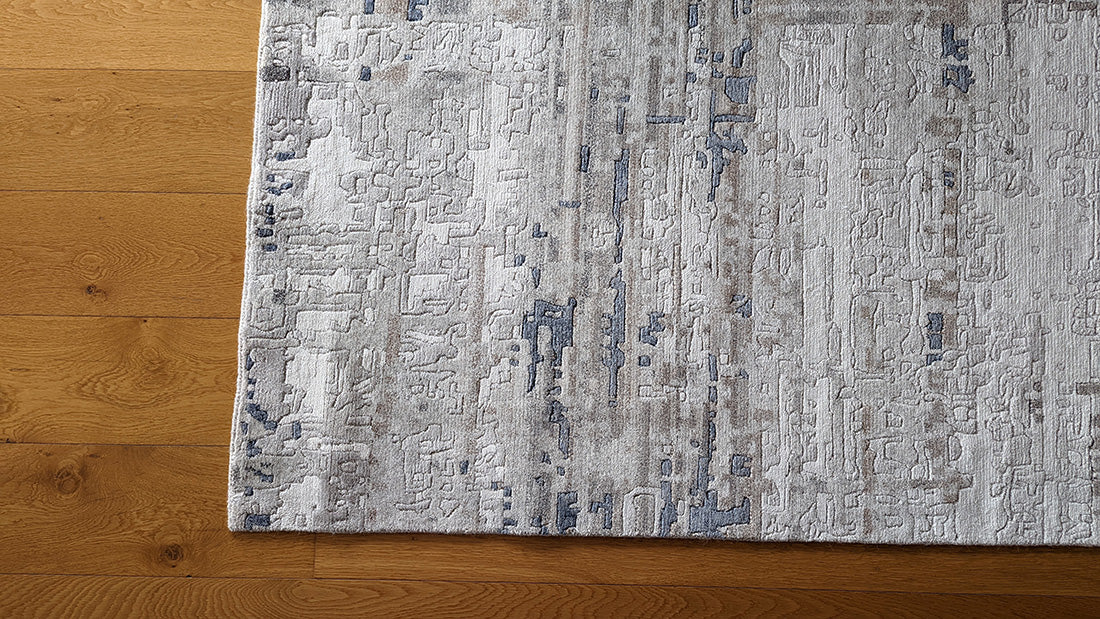 Area rug with abstract design in grey and beige