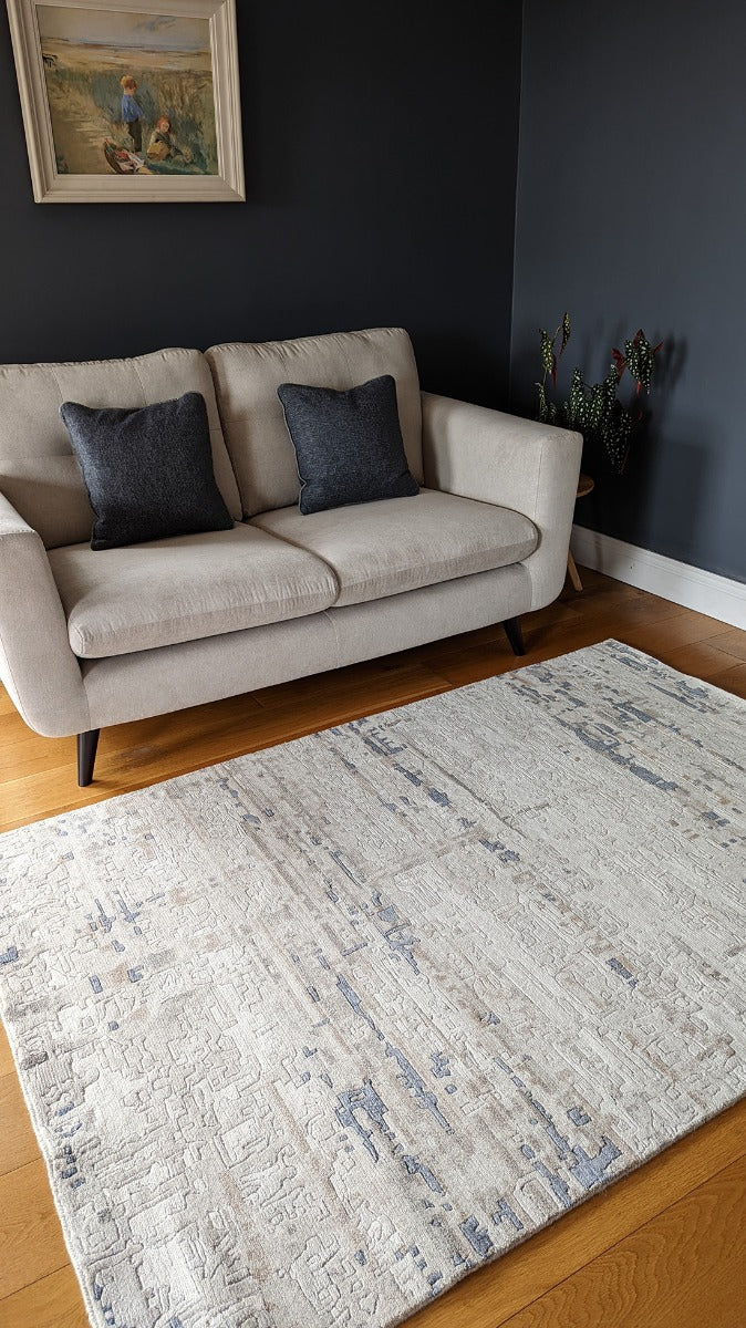 Area rug with abstract design in grey and beige