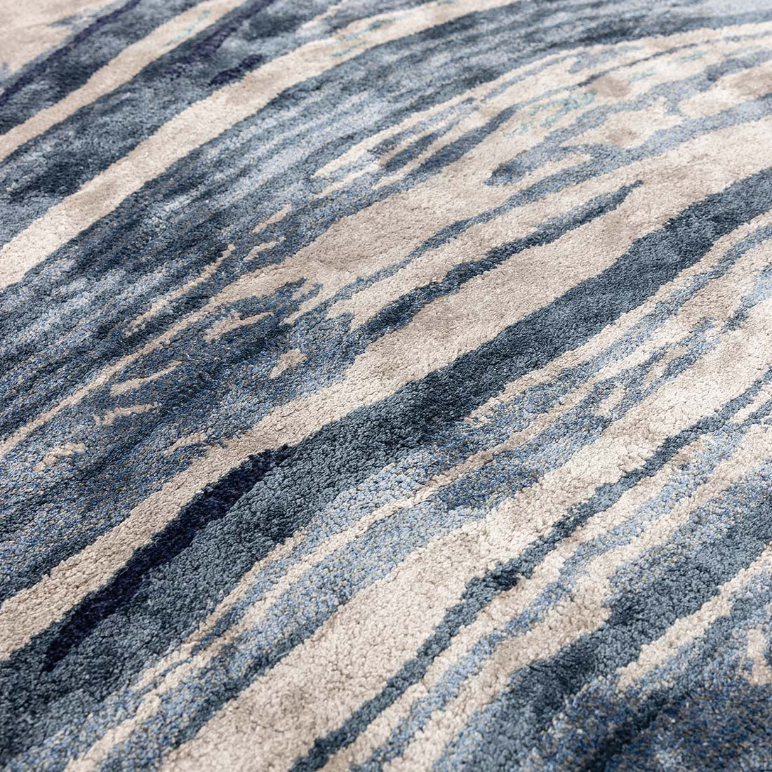 shiny blue and beige handtufted abstract rug in a marble design