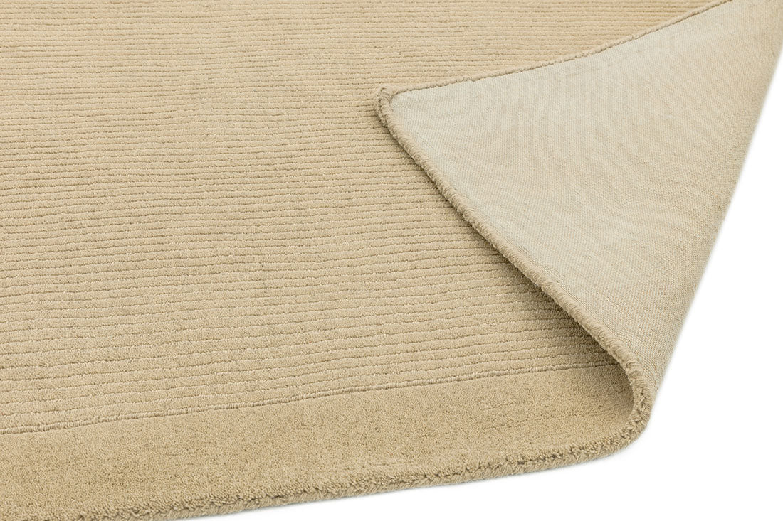 A plain beige rectangle-shaped wool rug with thin border.