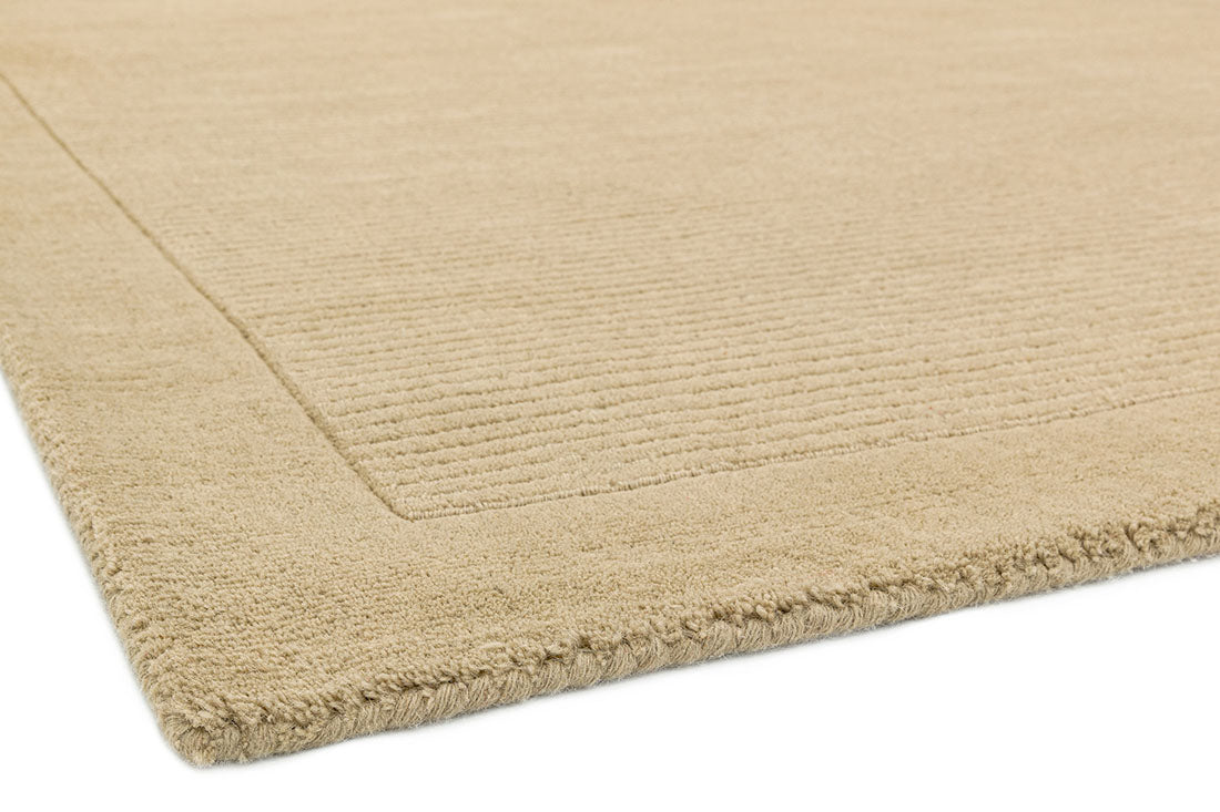 A plain beige rectangle-shaped wool rug with thin border.