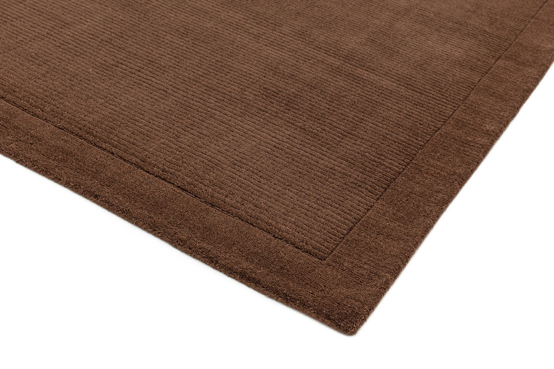 A plain brown rectangle-shaped wool rug with thin border.