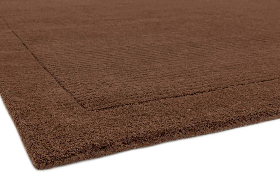 A plain brown rectangle-shaped wool rug with thin border.