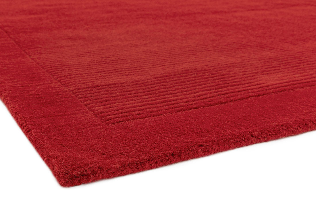 A plain red rectangle-shaped wool rug with thin border.
