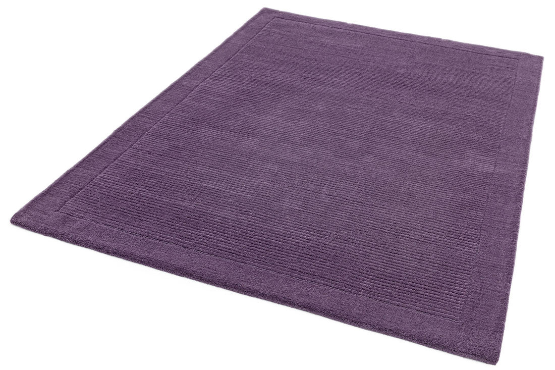 A plain purple rectangle-shaped wool rug with thin border.