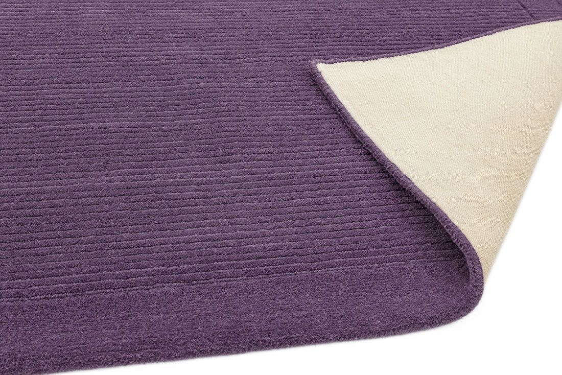 A plain purple rectangle-shaped wool rug with thin border.