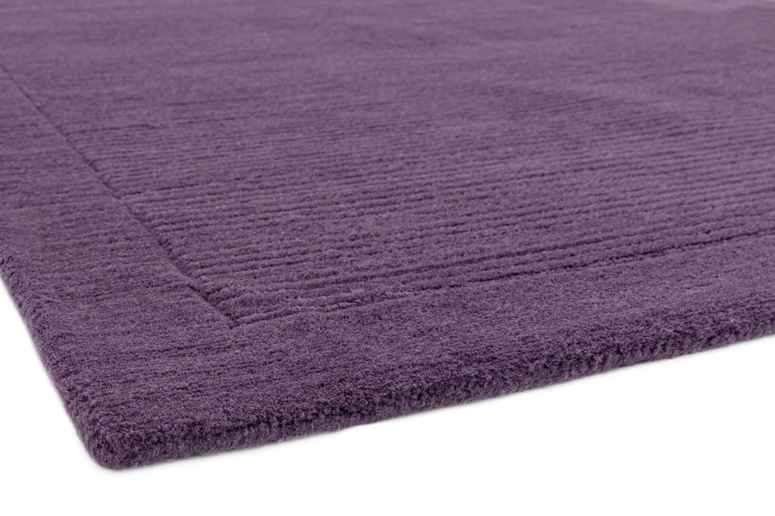 A plain purple rectangle-shaped wool rug with thin border.