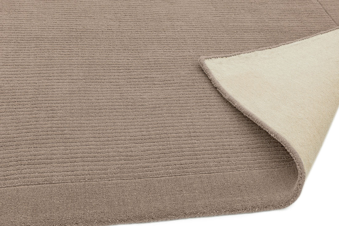 A taupe brown rectangle-shaped wool rug with thin border.
