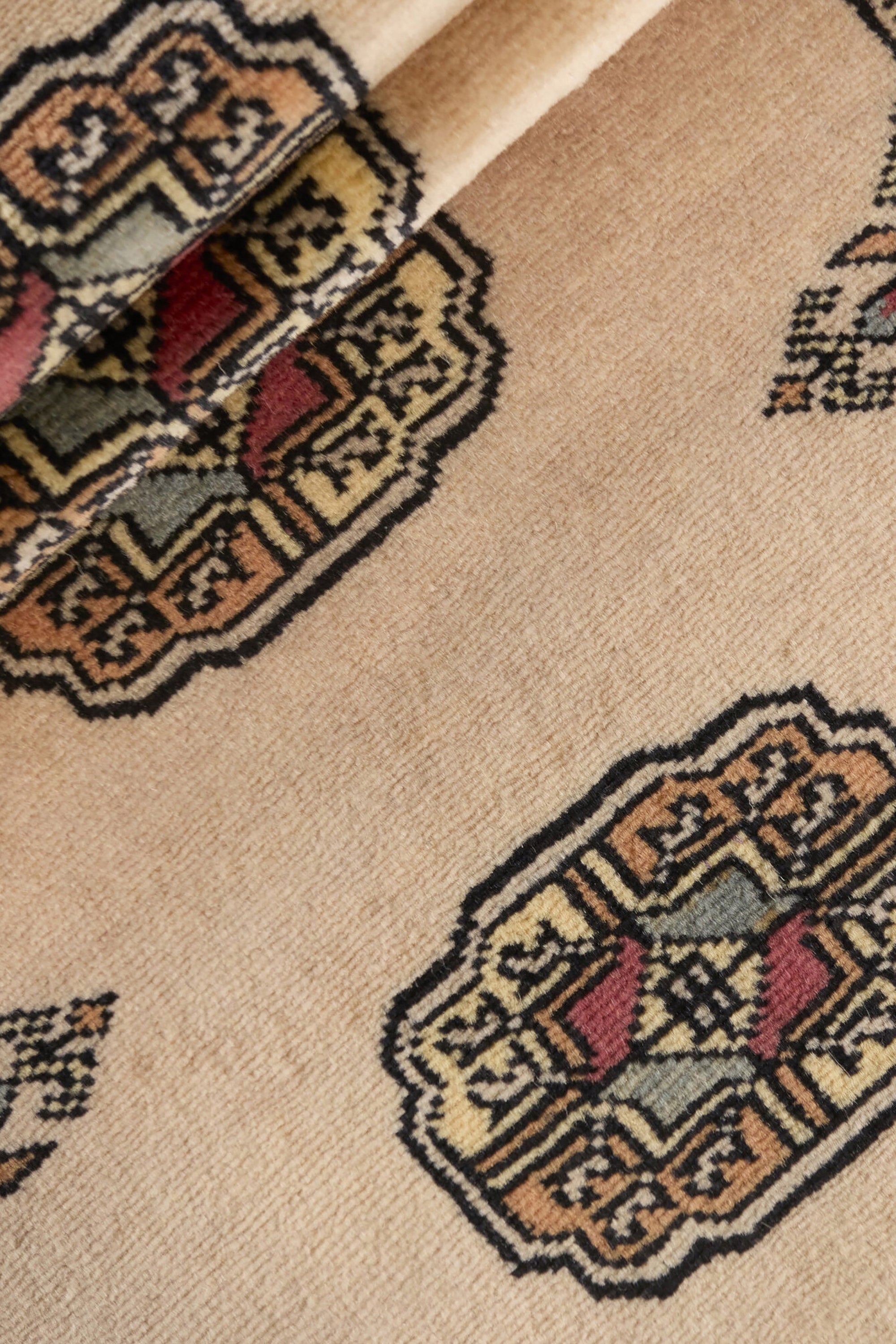 Beige Oriental runner with traditional bordered pattern