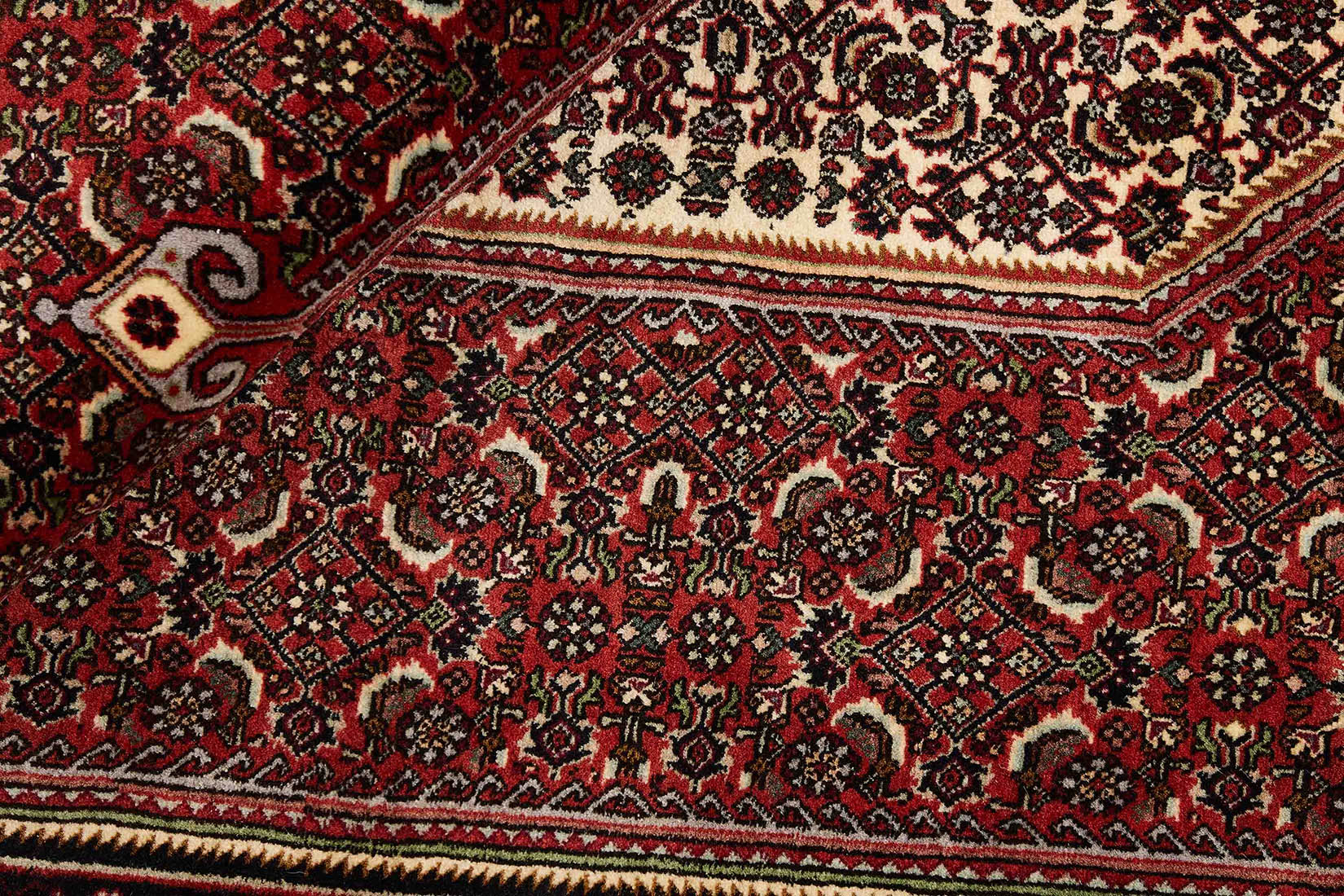 Red and cream persian rug with traditional floral design
