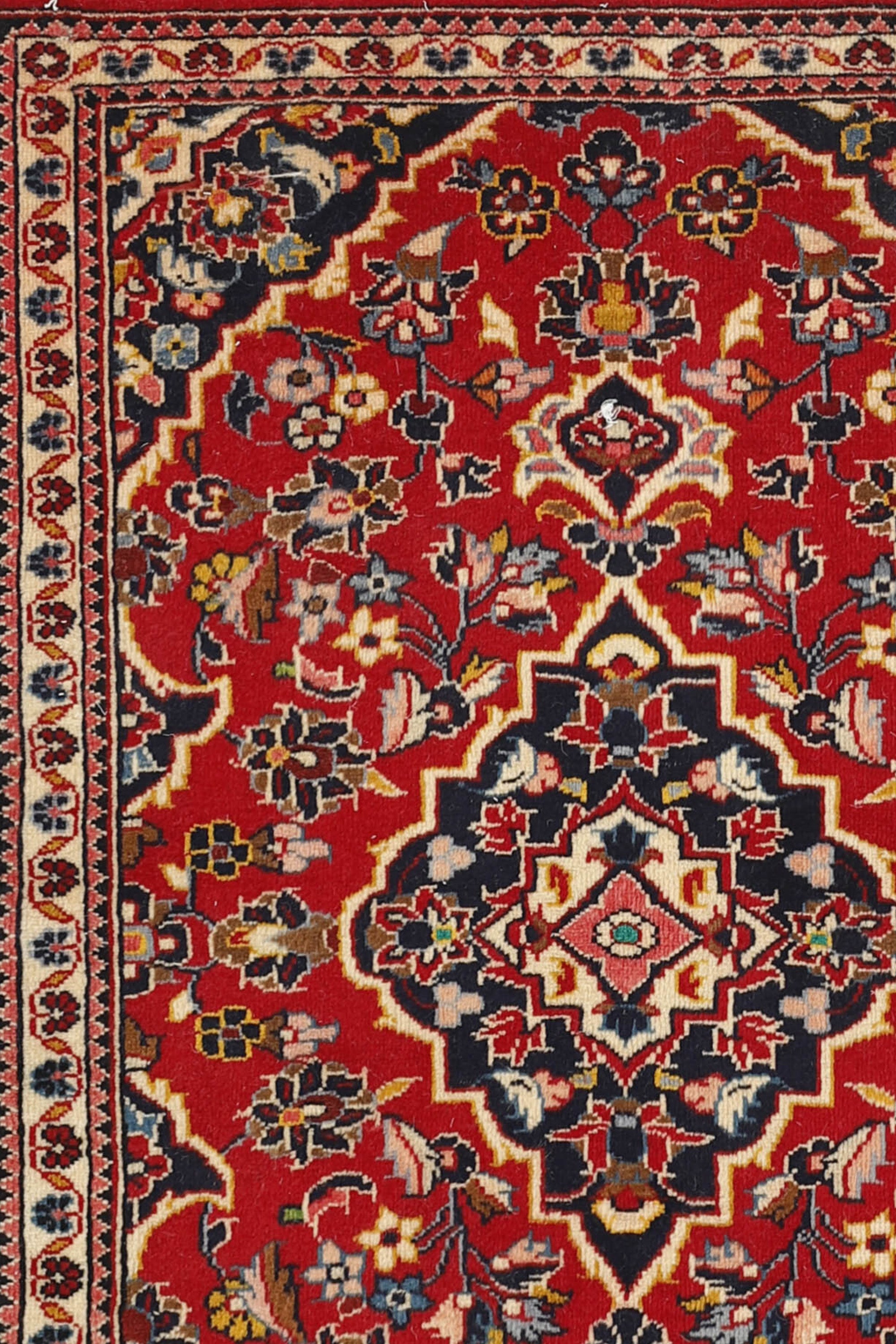 Traditional bordered Keshan rug with red background