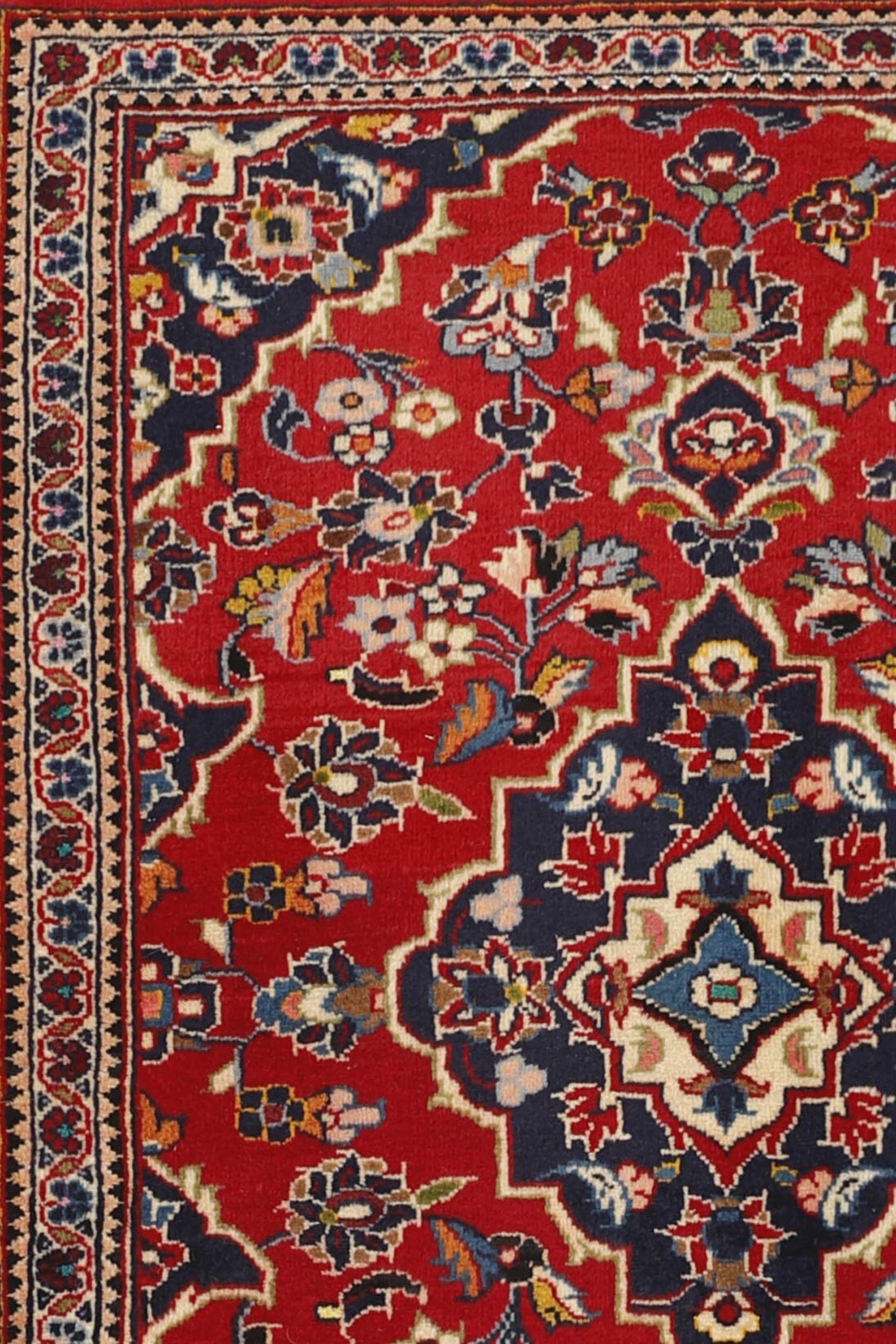 Traditional bordered Keshan rug with red background