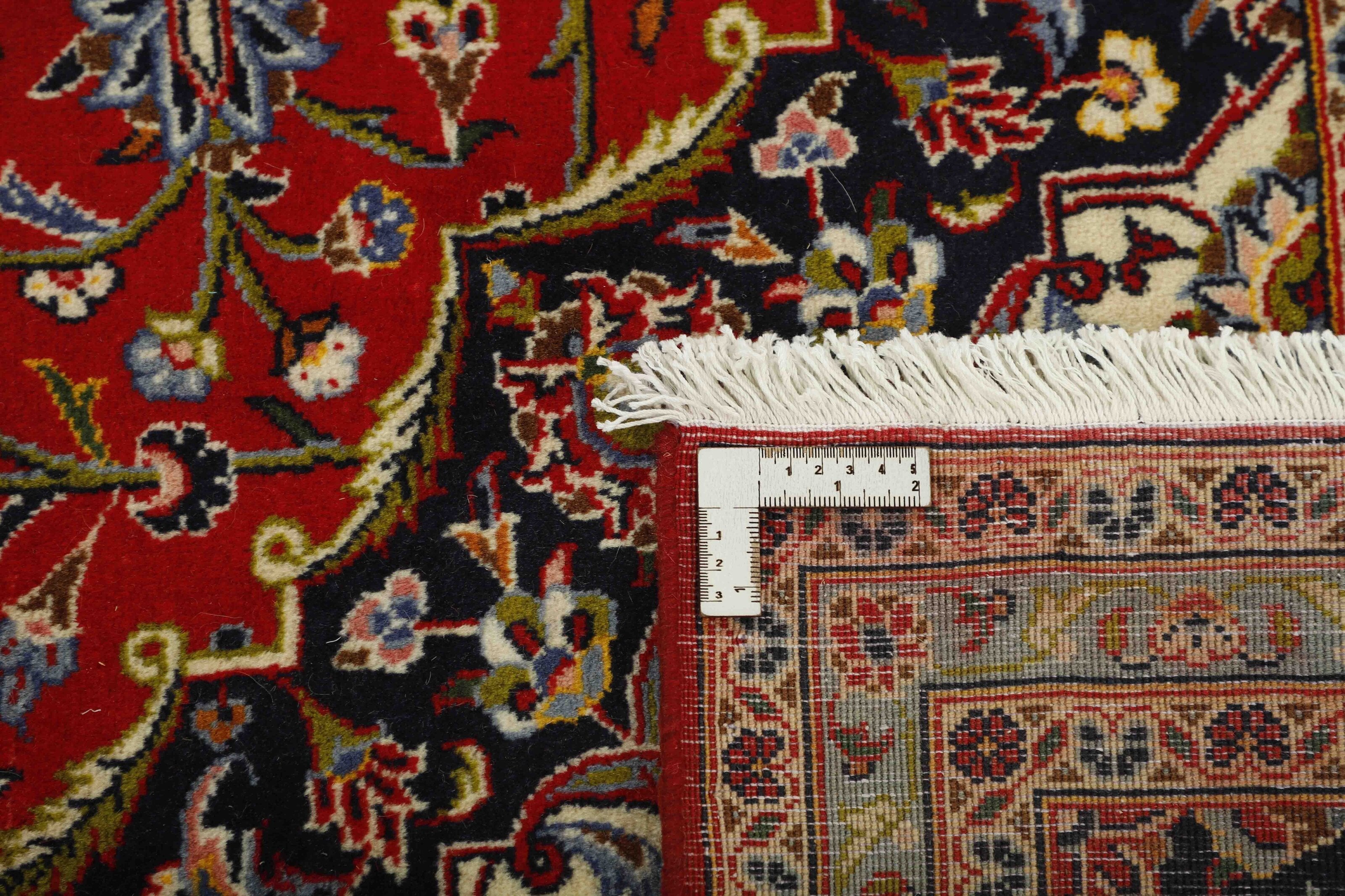 Traditional bordered Keshan rug with red background