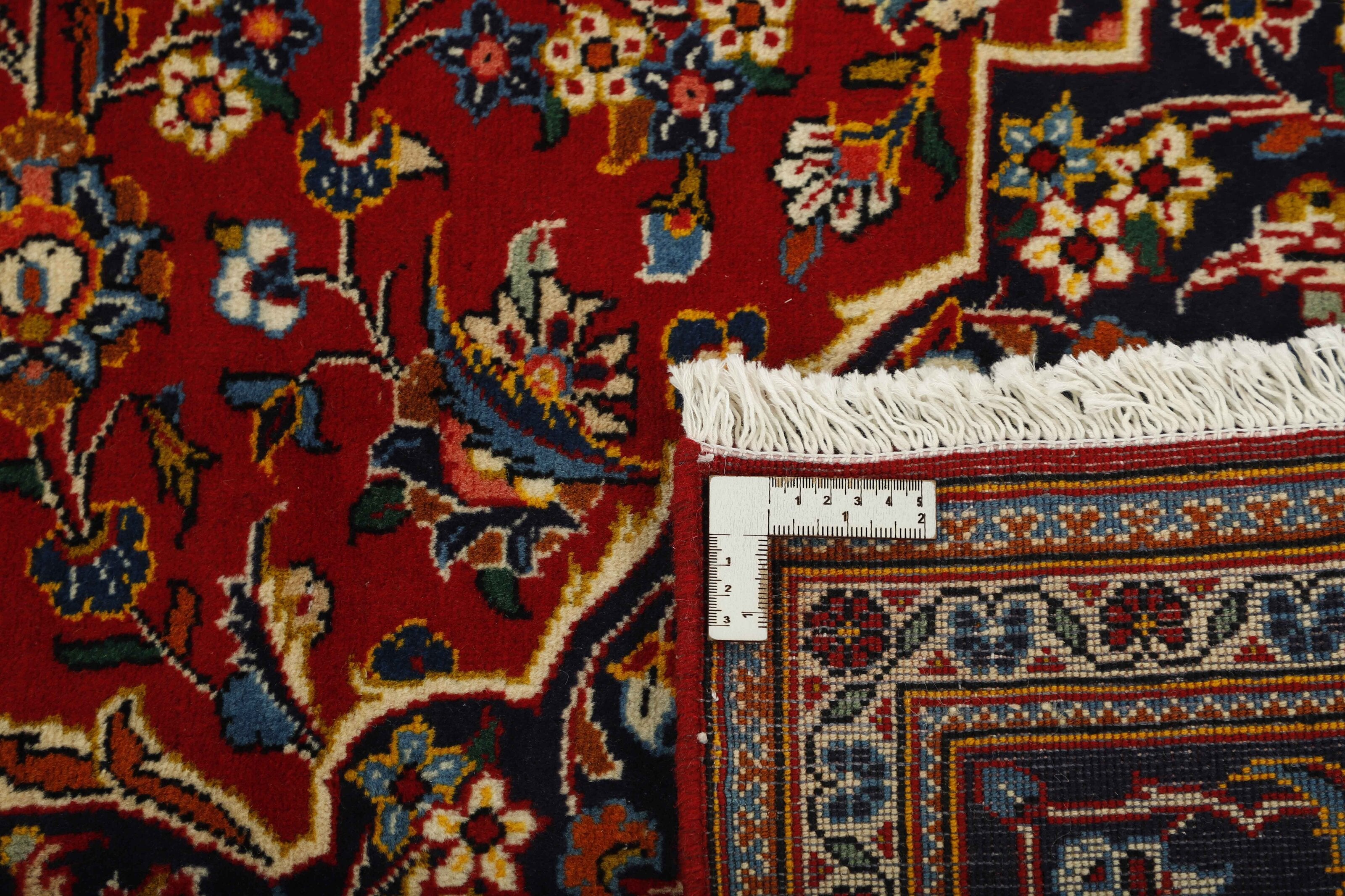 Traditional bordered Keshan rug with red background