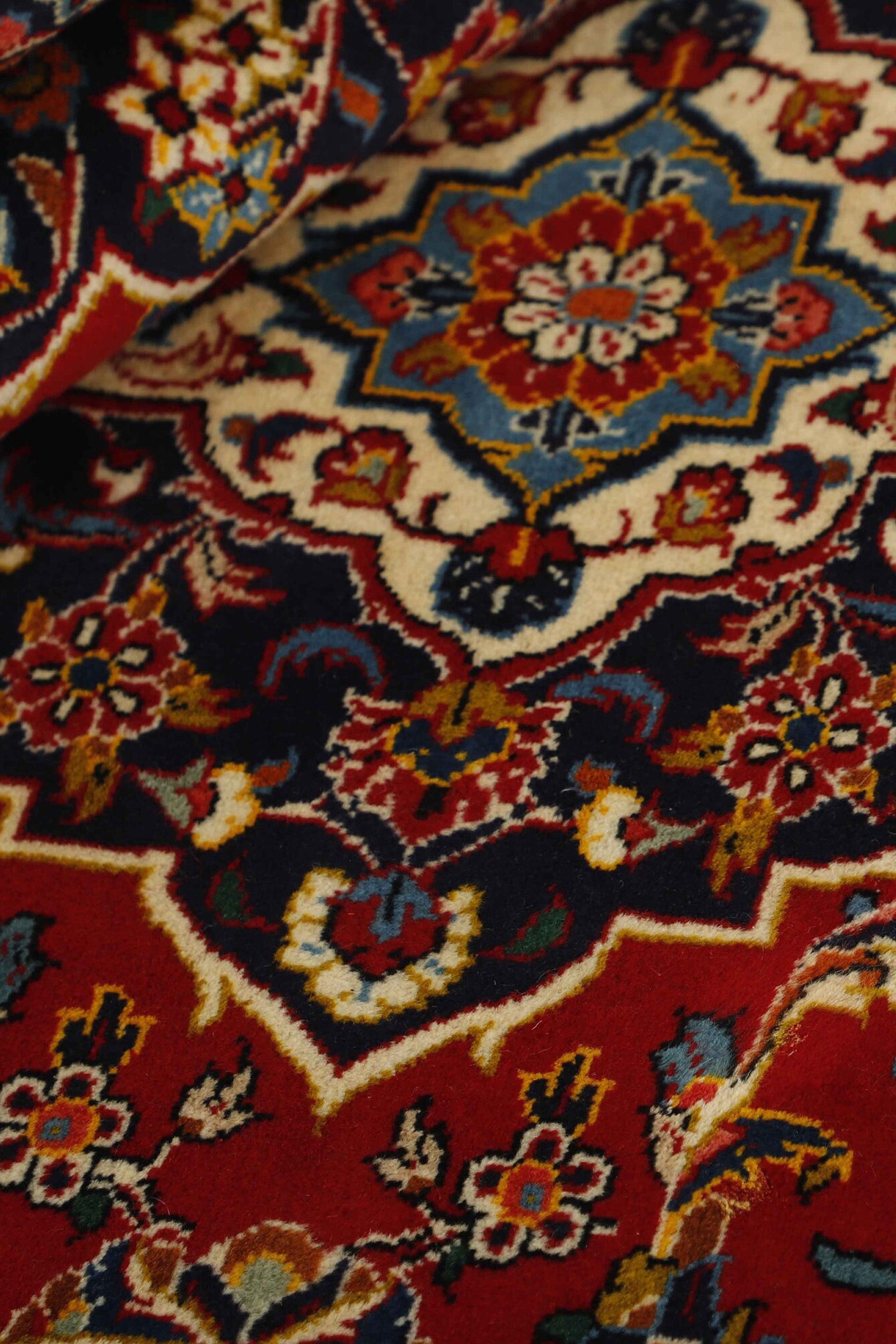 Traditional bordered Keshan rug with red background