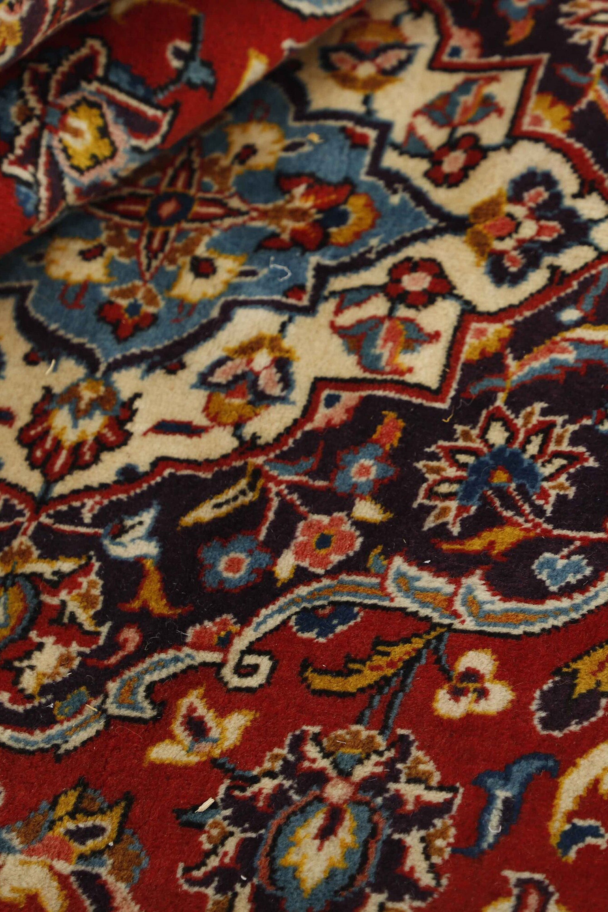 Traditional bordered Keshan rug with red background