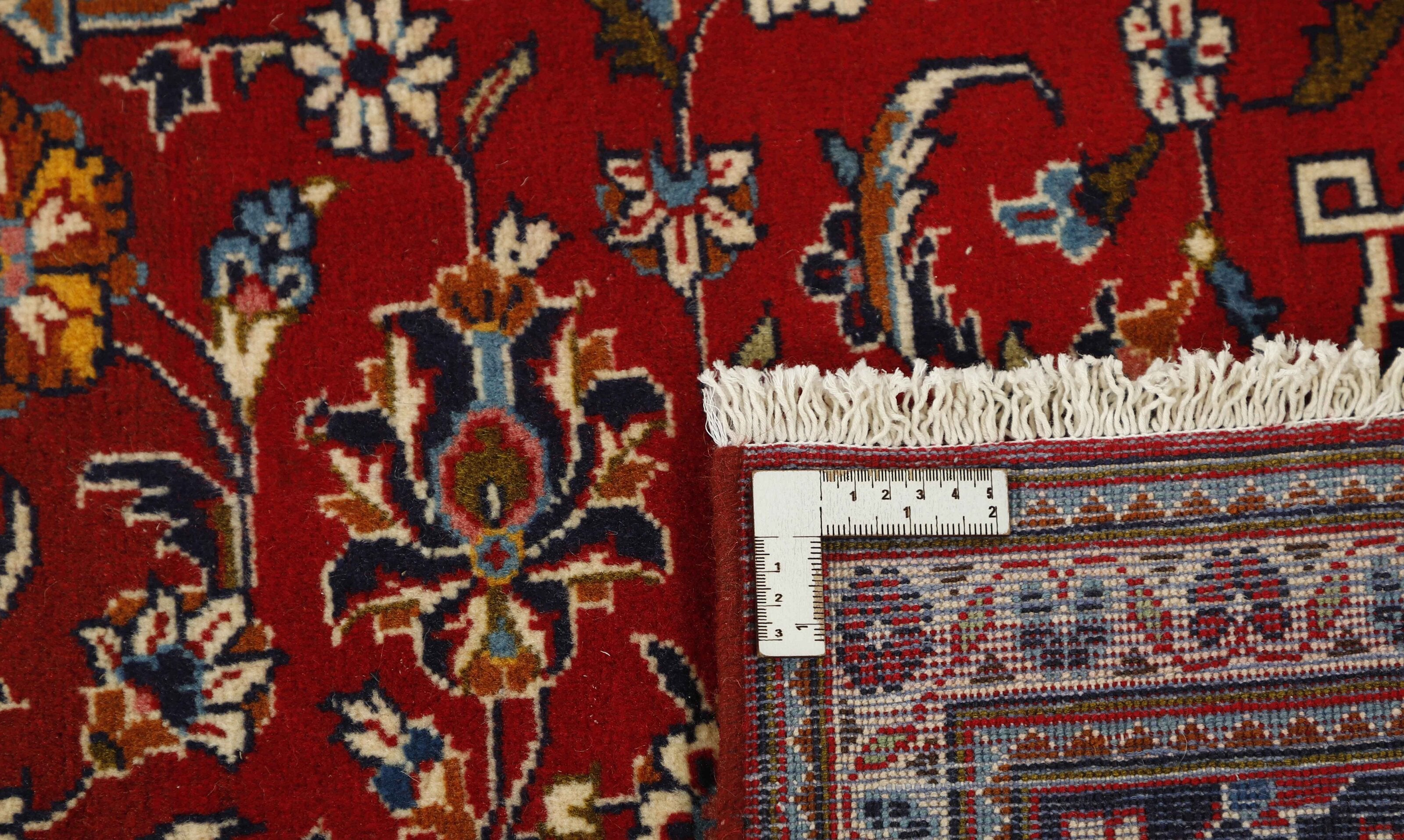 Traditional bordered Keshan rug with red background