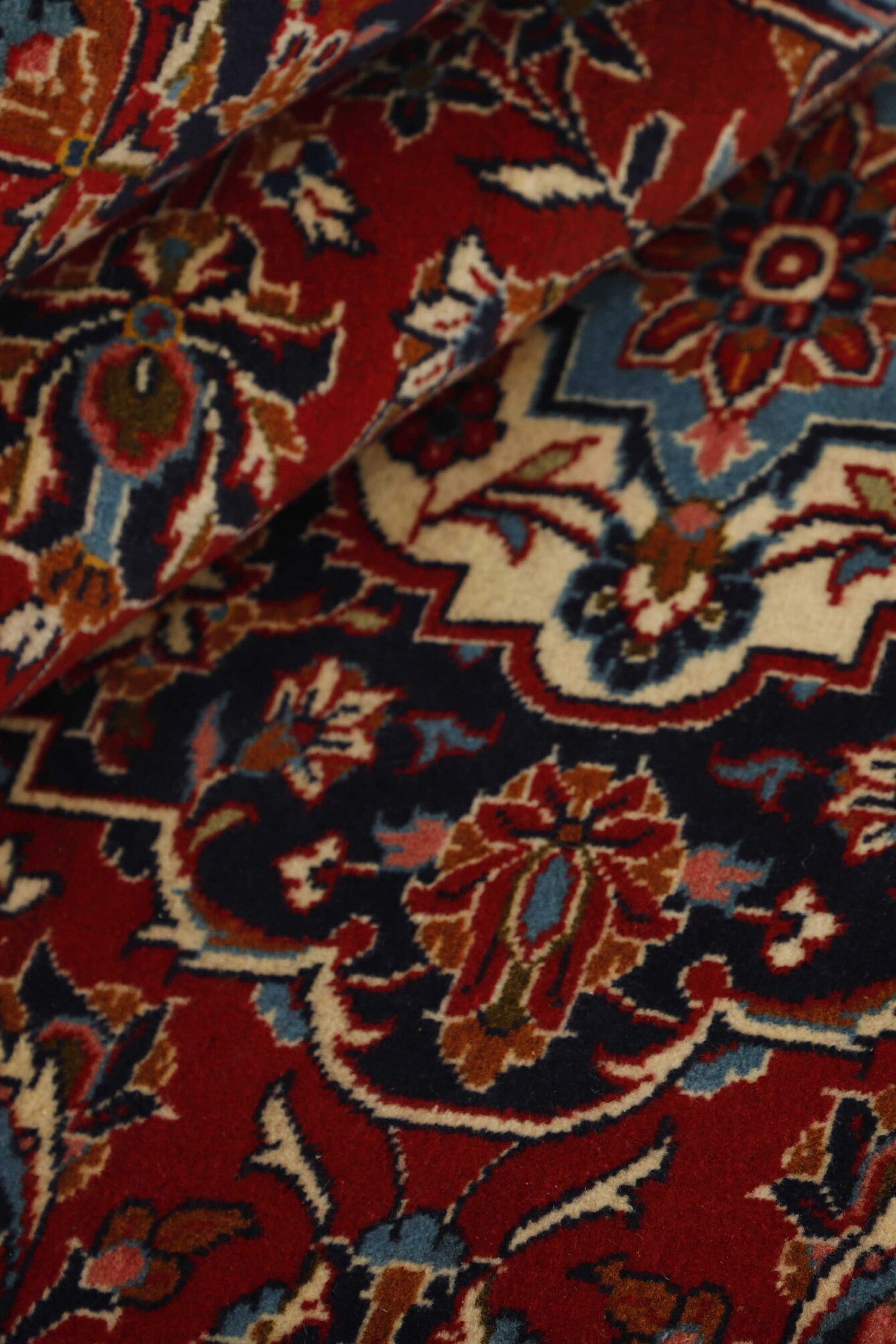 Traditional bordered Keshan rug with red background