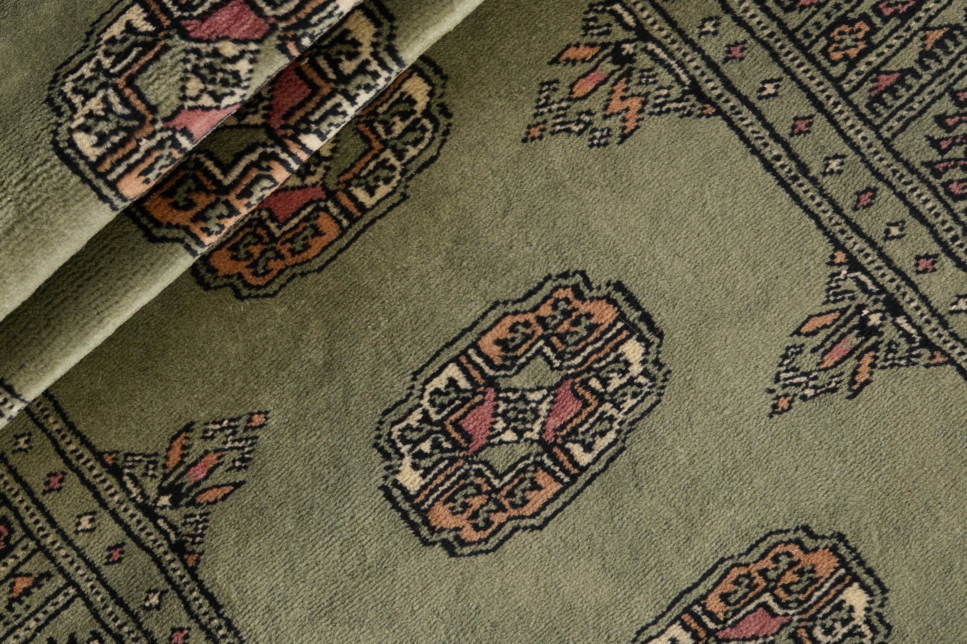 Green Oriental runner with traditional bordered pattern