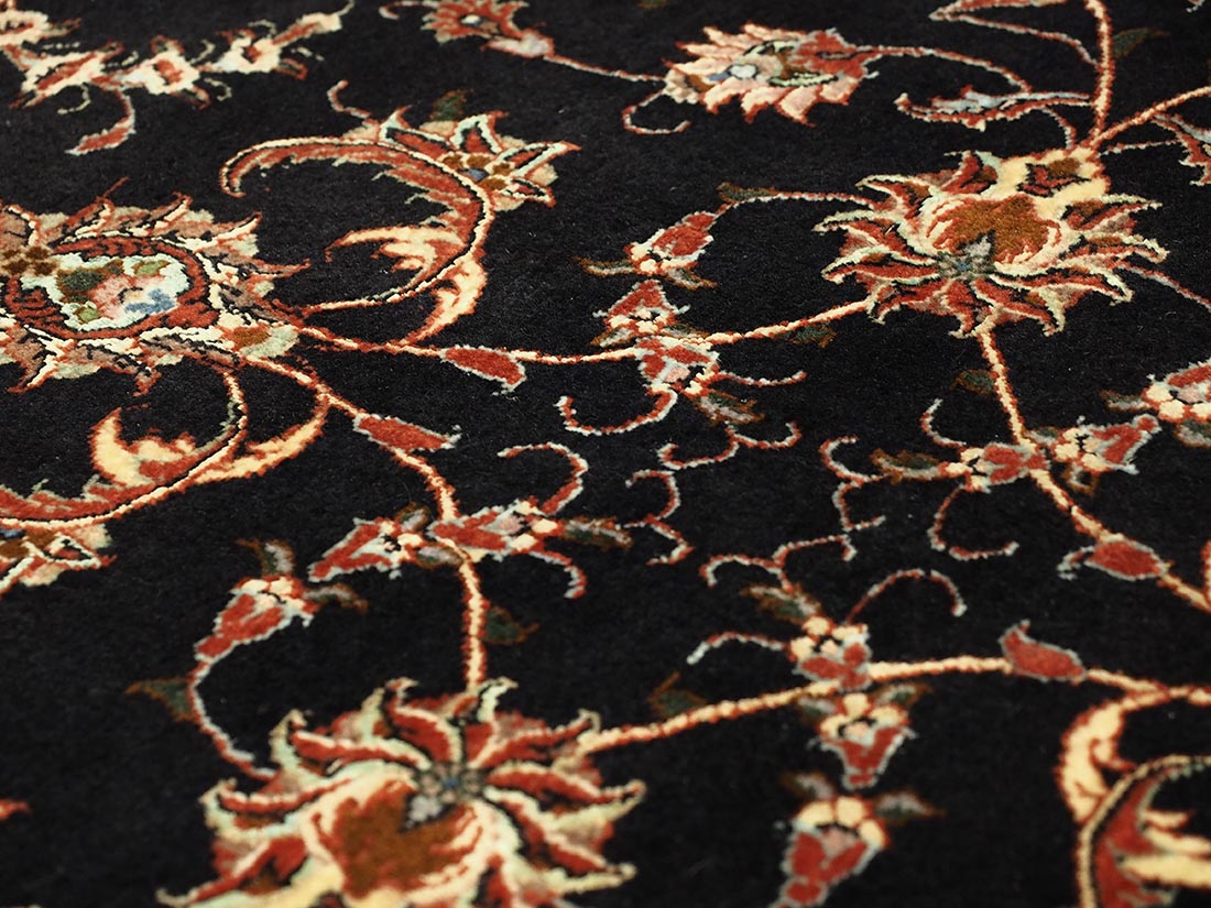 Red and black persian rug with traditional floral design