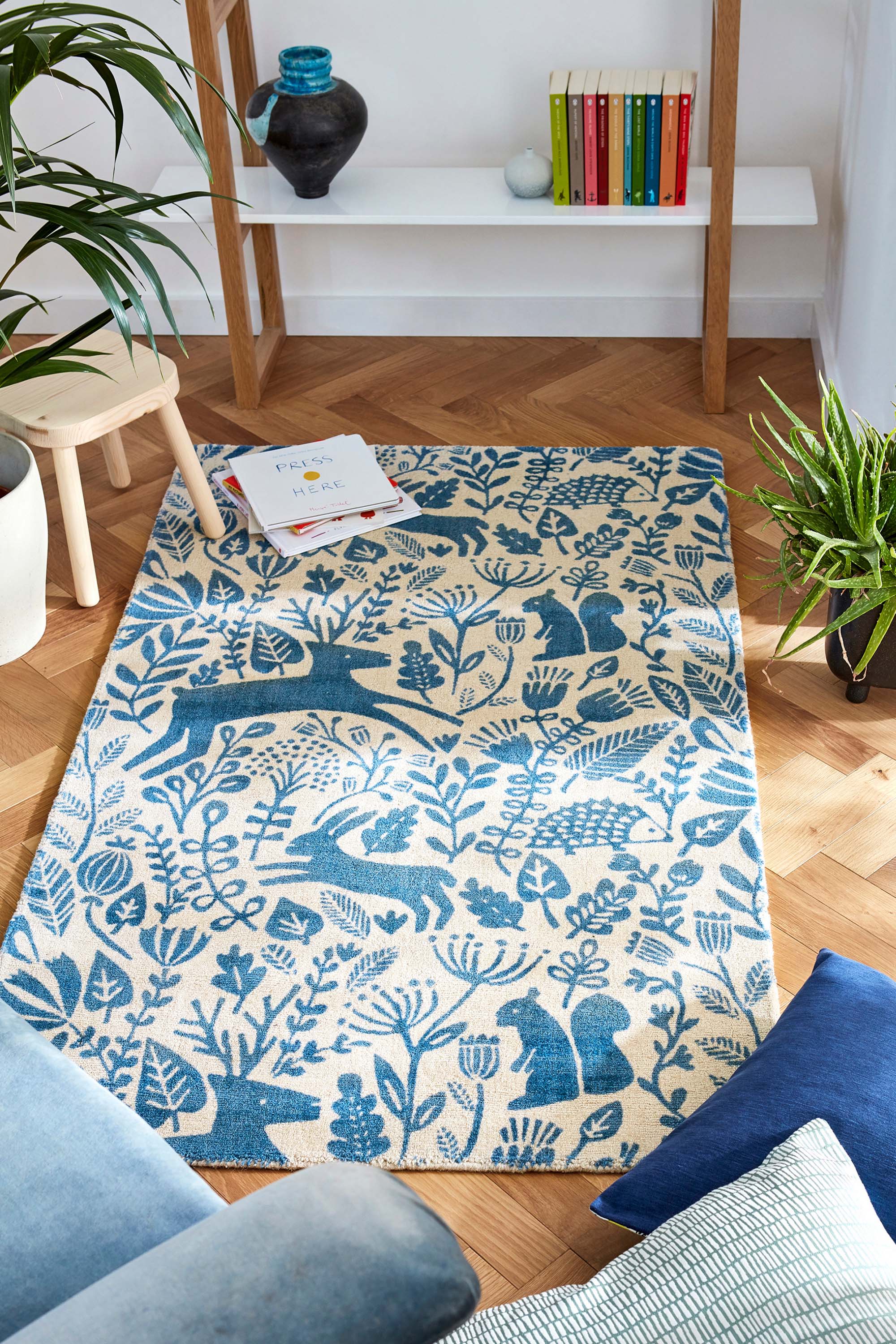 blue wool rug with a delicate woodland design
