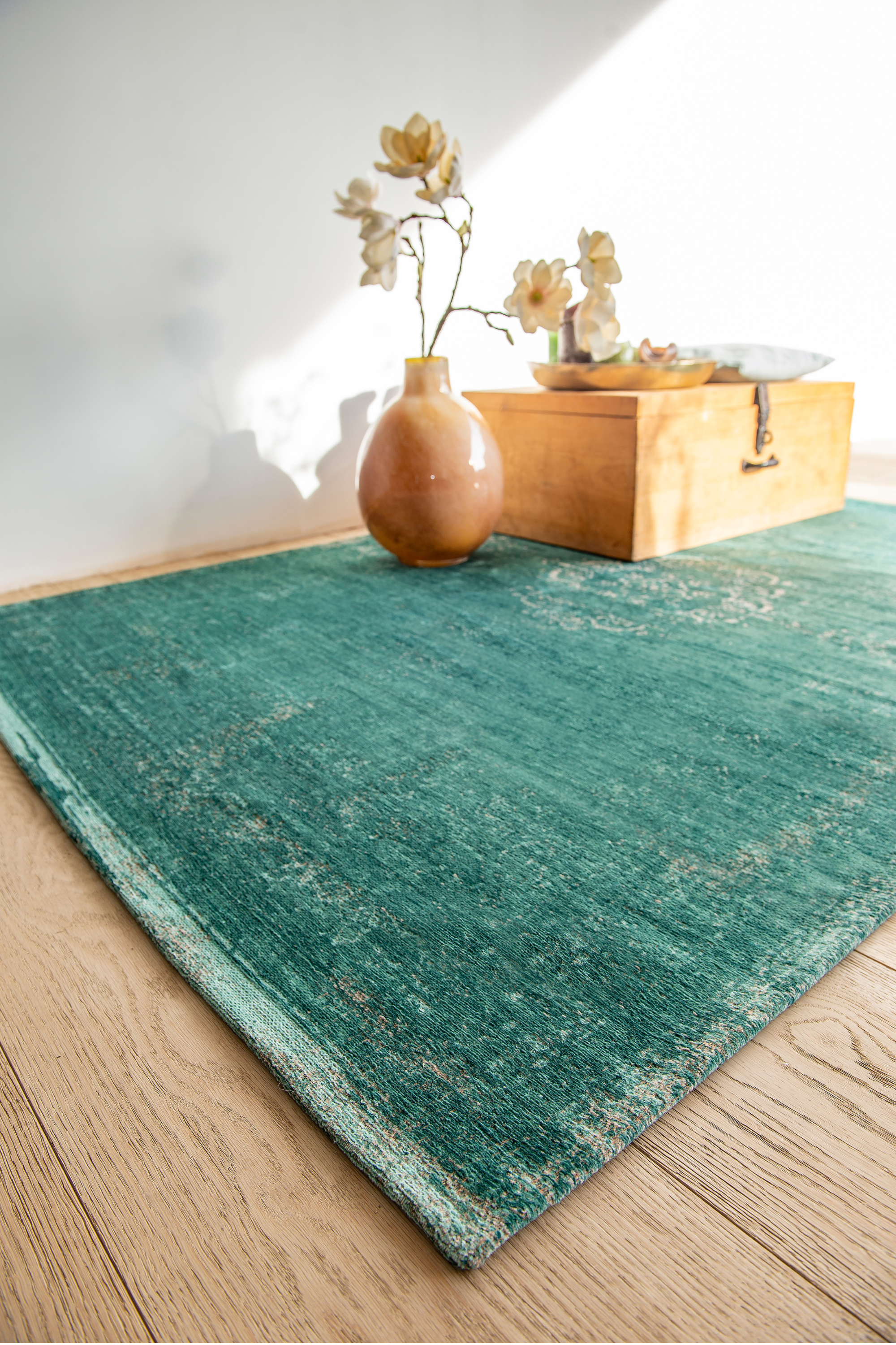 green flatweave rug with faded persian design