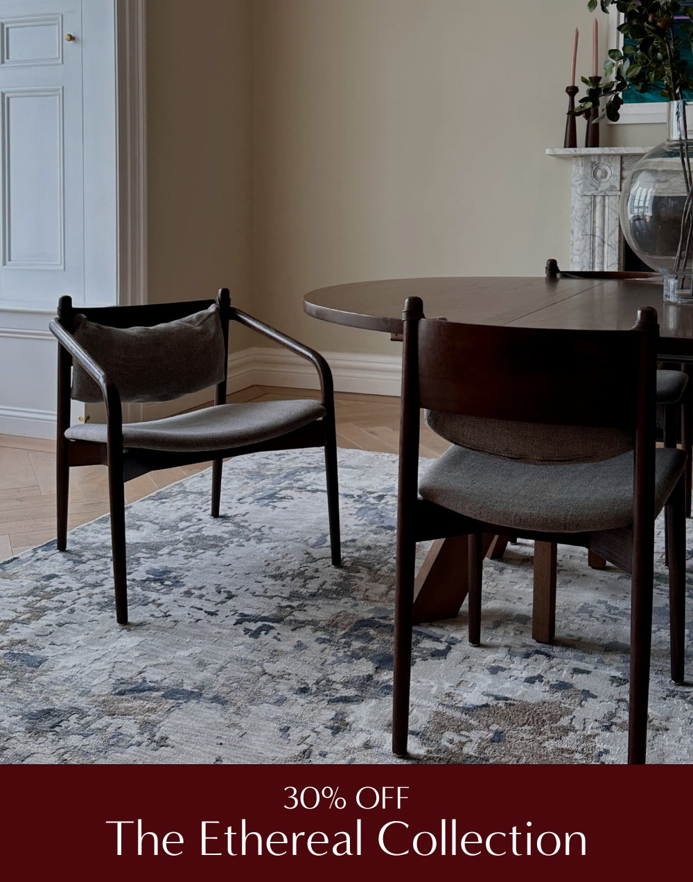 Dining room with wooden table and chairs on a patterned rug, featuring 'The Ethereal Collection' discount text.