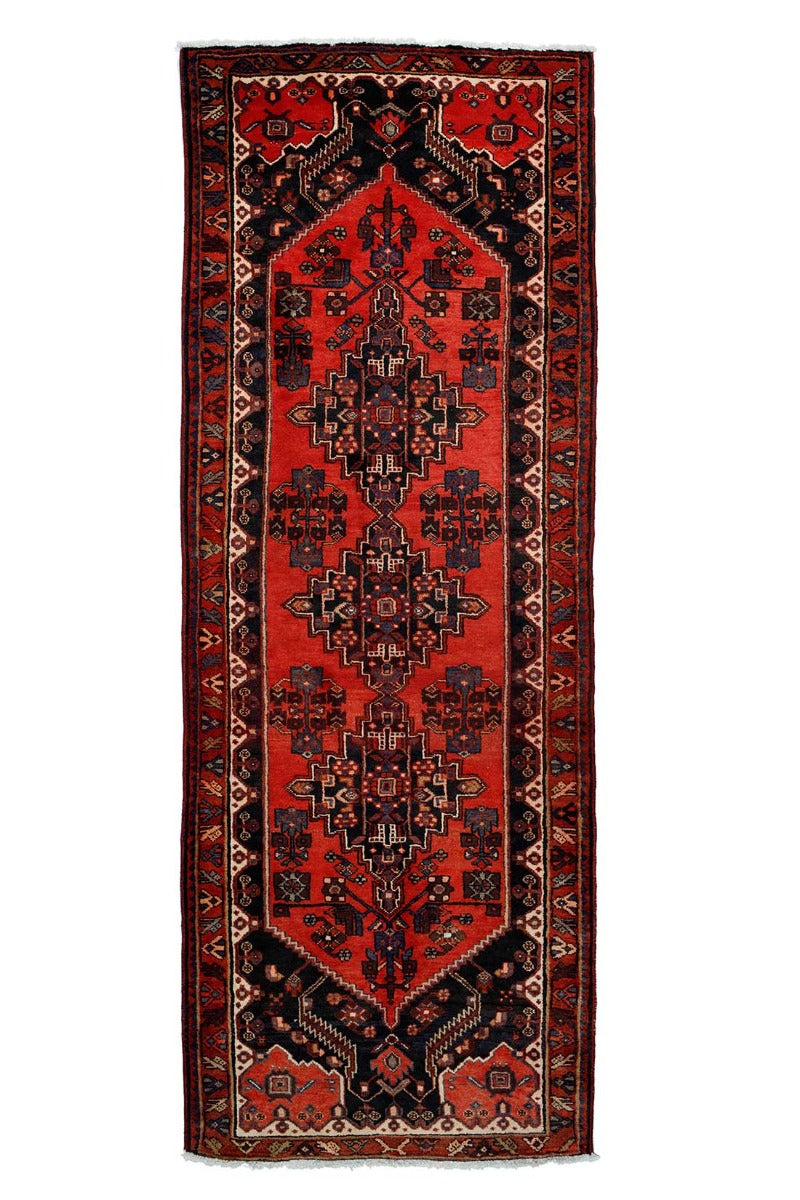 Handknotted Persian runner rug in red with touches of black and cream 
